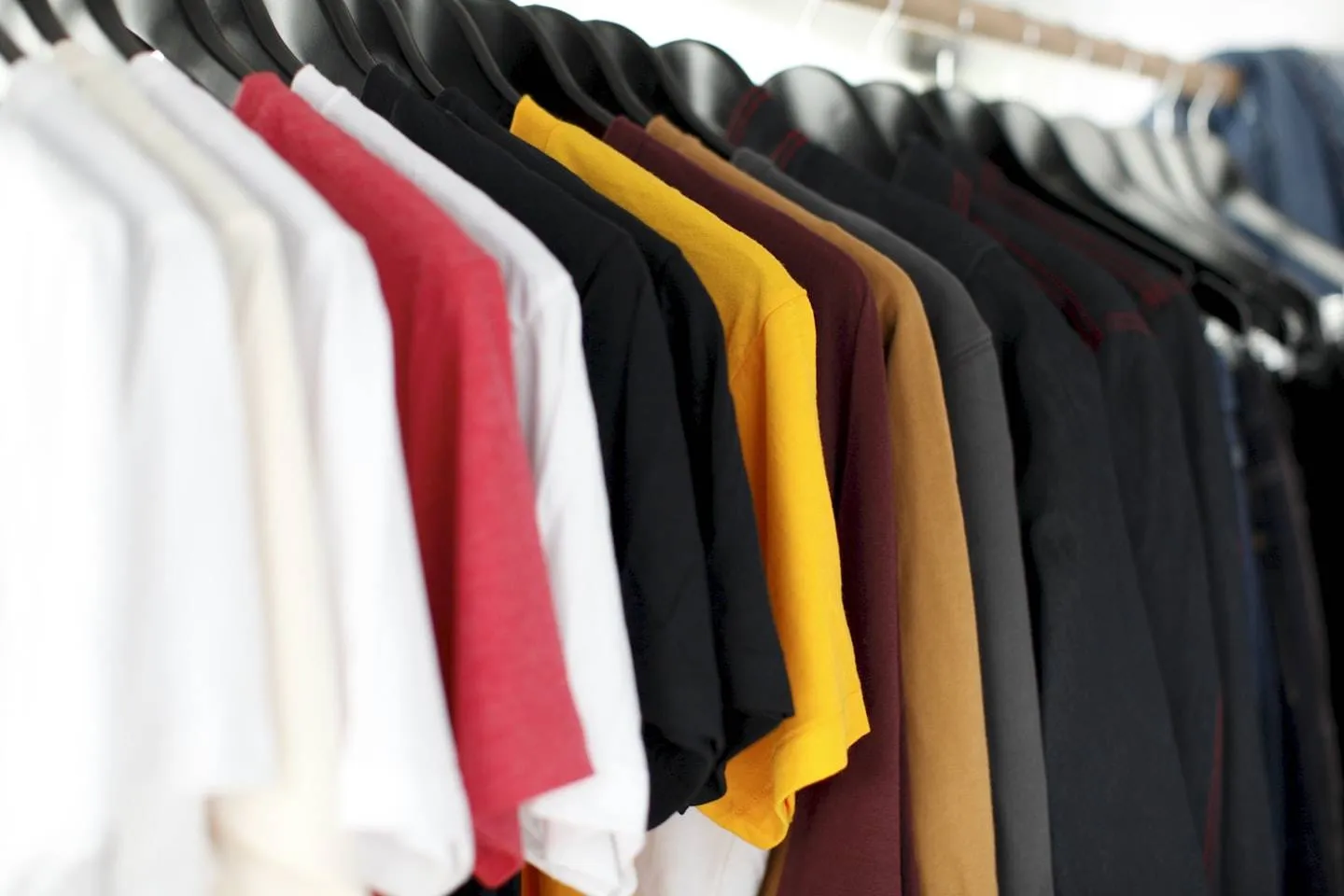 Colorful shirts and clothing hanging on a rack